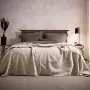 Couvre-lit réversible sur un lit de couleur beige