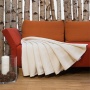 Couverture polaire dans un coloris naturel clair sur un sofa