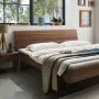 Elegant zwevend bed met comfortabel gebogen hoofdeinde, hier in massief notenhout