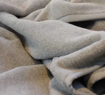 Couverture de couleur gris argenté avec bordure texturée en laine
