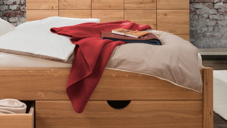Confortable couverture polaire en coton sur un lit - ici in rouge