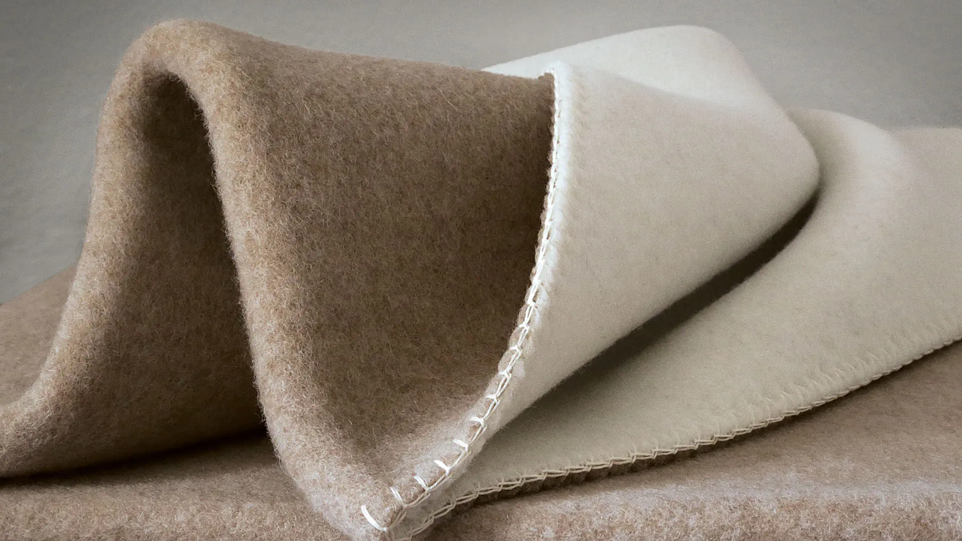 Huiselijke deken van merino schapenwol in de kleurstelling beige/wit